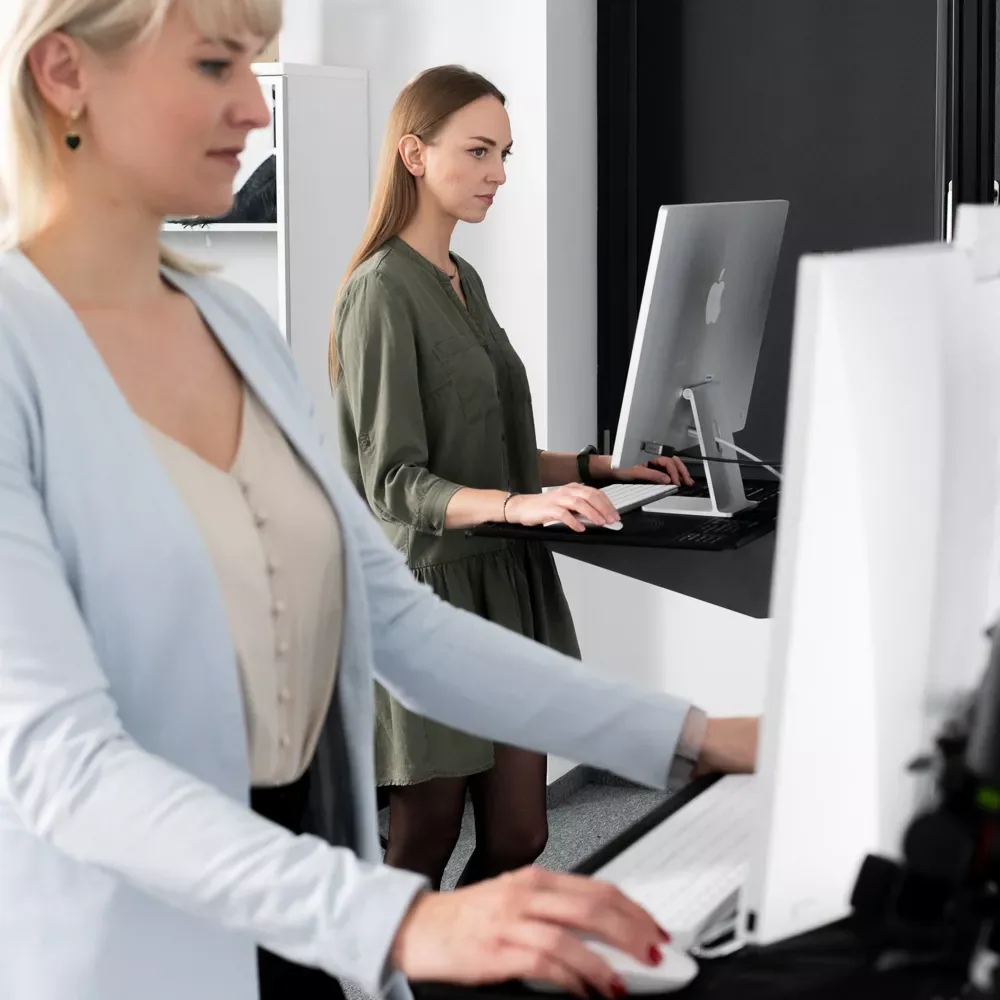 Dos mujeres trabajando en ordenadores en un estudio fotográfico de Orbitvu.