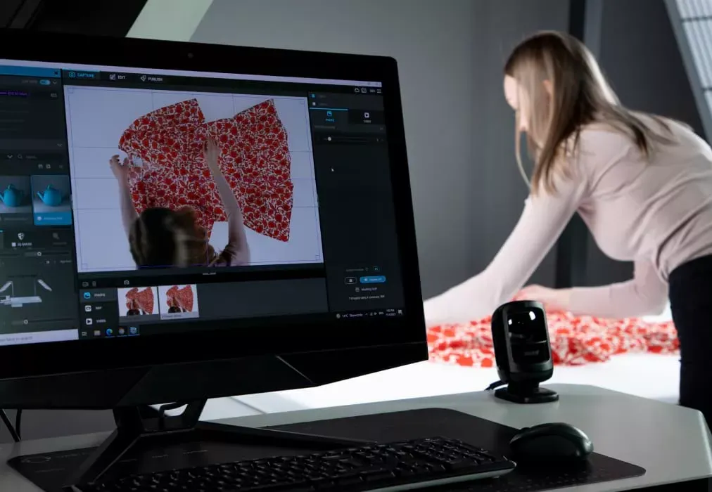Fotógrafo ajustando una prenda de tela floral con vista en vivo en el monitor