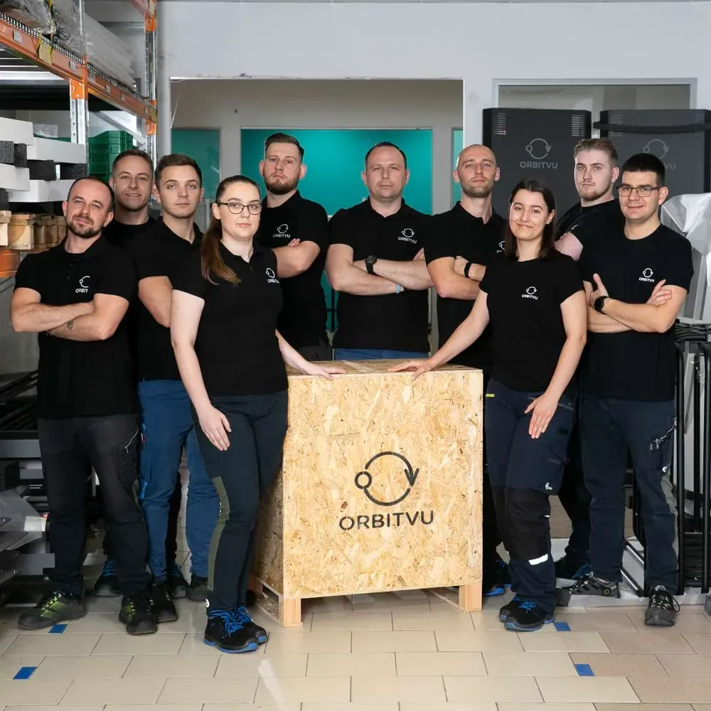 Equipo de producción y logística de Orbitvu posando con una caja de madera con la marca