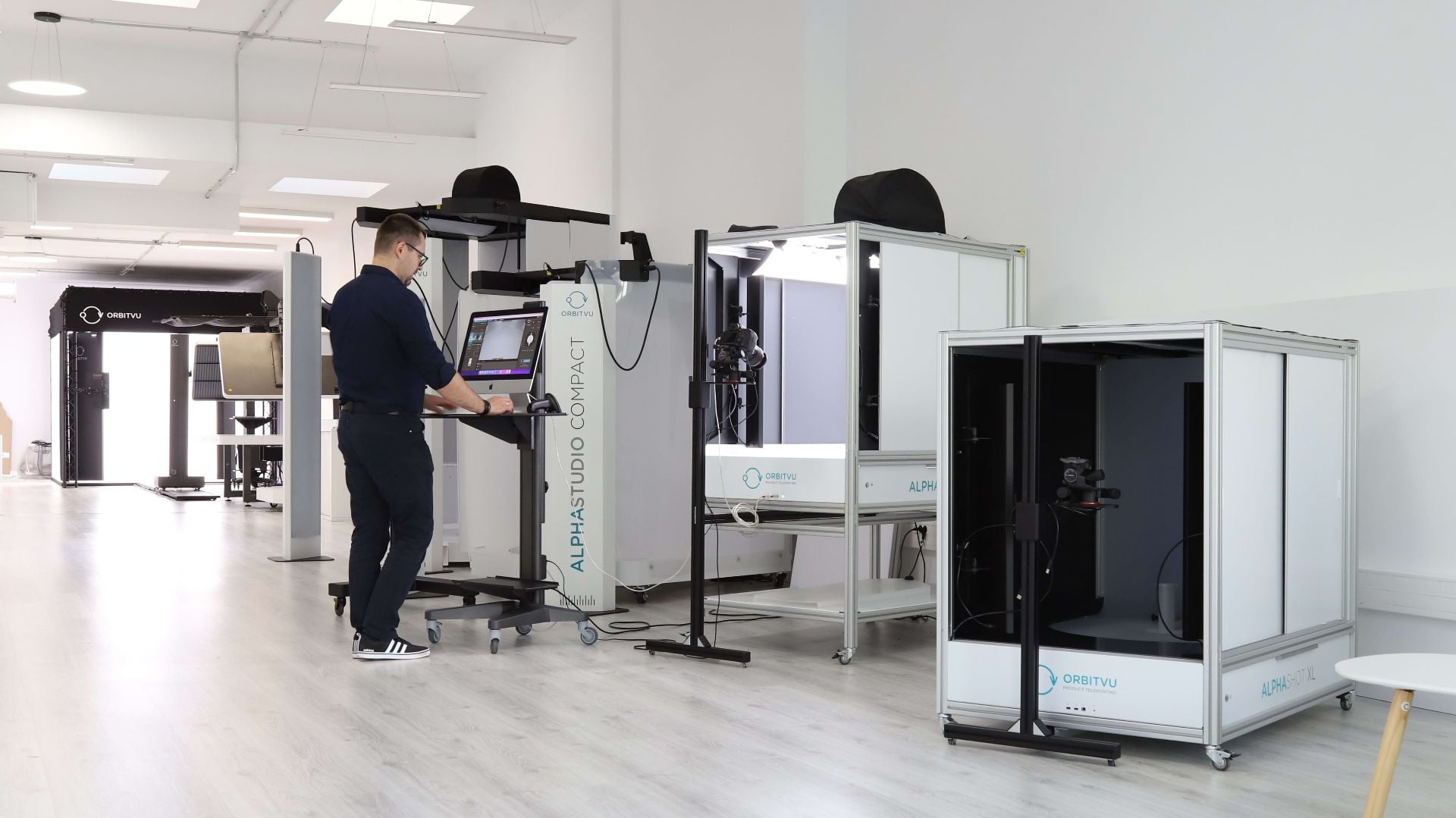 Operador de estudio de e-commerce trabajando con máquinas de fotografía de productos Orbitvu
