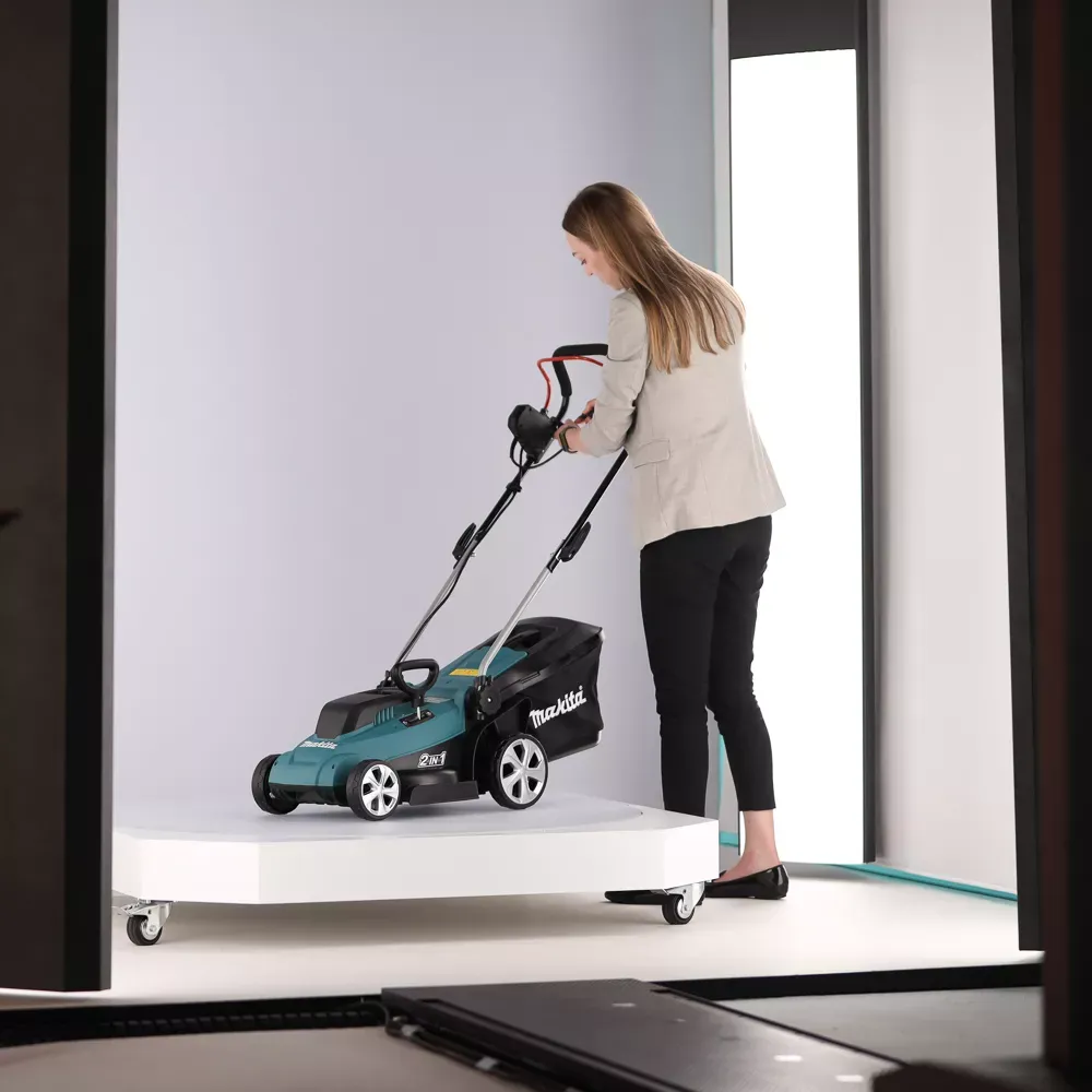 Mujer manejando un cortacésped inalámbrico Makita en un estudio
