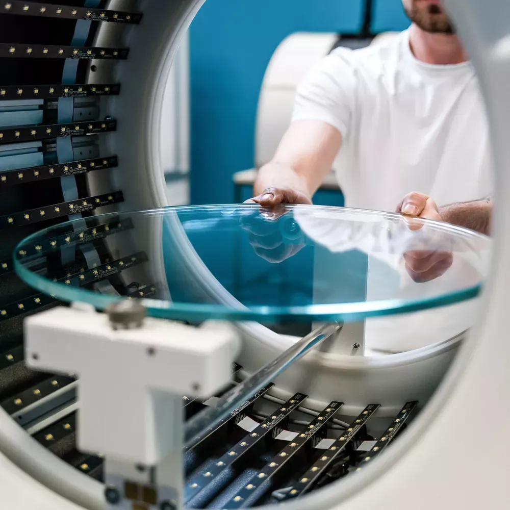 Técnico colocando una plataforma giratoria de cristal en un estudio fotográfico automatizado
